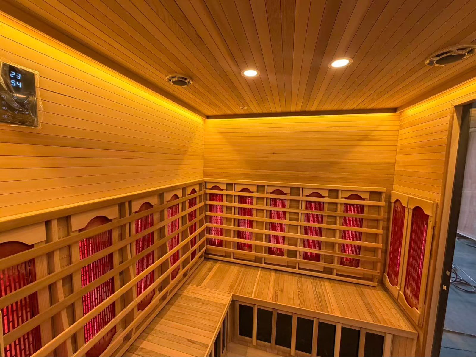 Interior of the commercial infrared sauna showing heating panels, L-shaped benches and control panel