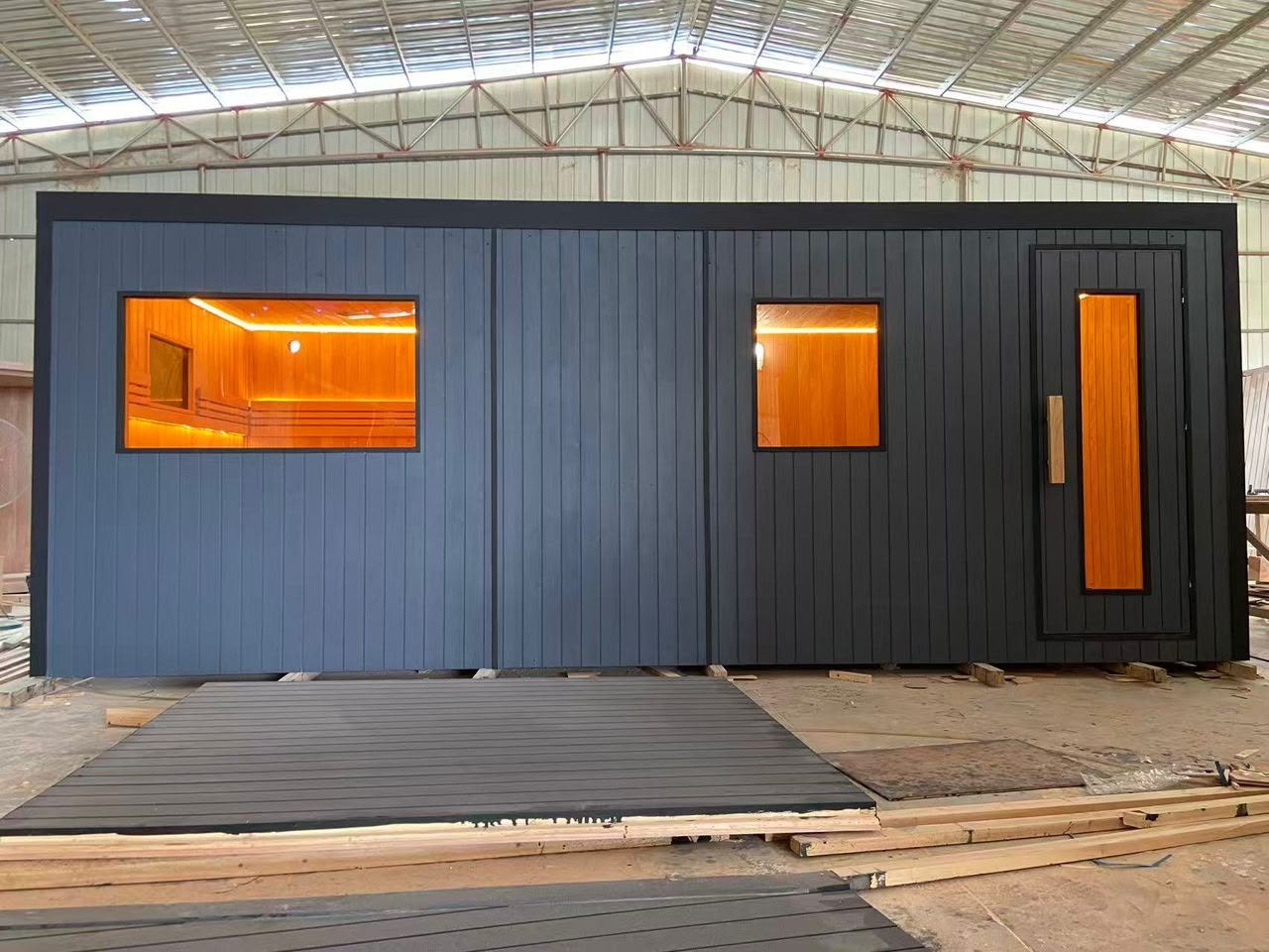 Large commercial sauna with black exterior shell and illuminated glazing